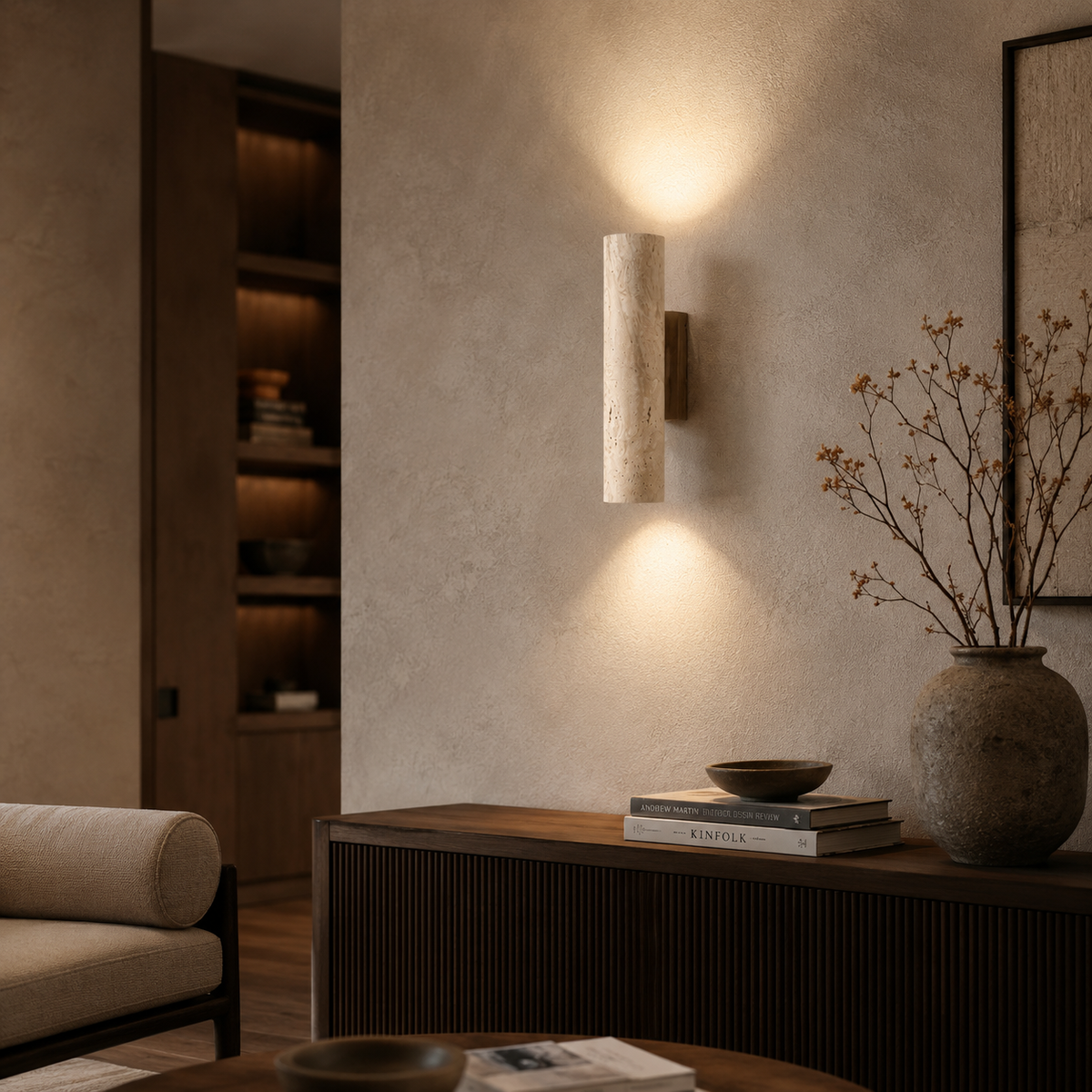 Modern interior design with wall sconce, books, and vase in a living room setting