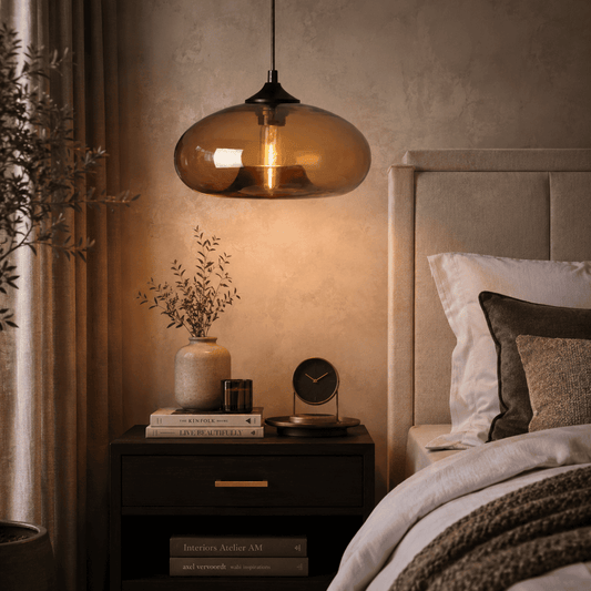 A warm amber glass pendant light hangs over a dark wood nightstand