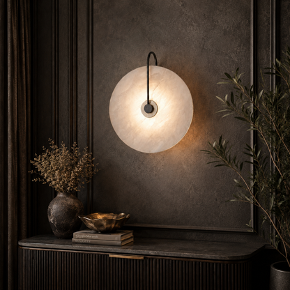 A modern circular wall sconce with a textured white shade and a black metal arm