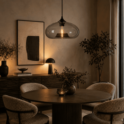 A clear glass dome pendant light hanging above table