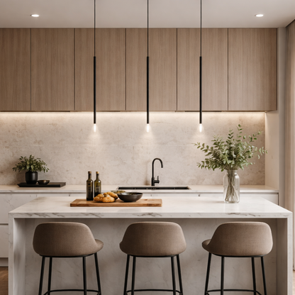 A modern kitchen interior with light wood cabinets and three slim black pendant lights