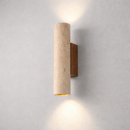 A modern wall-mounted sconce with a cylindrical beige travertine stone shade and a rectangular dark brown wood backplate