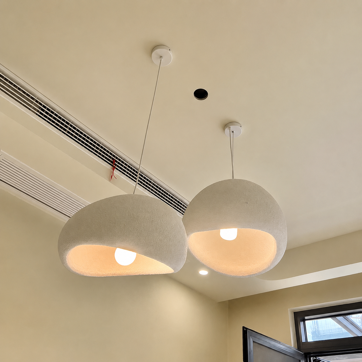 Two modern pendant light fixtures with textured