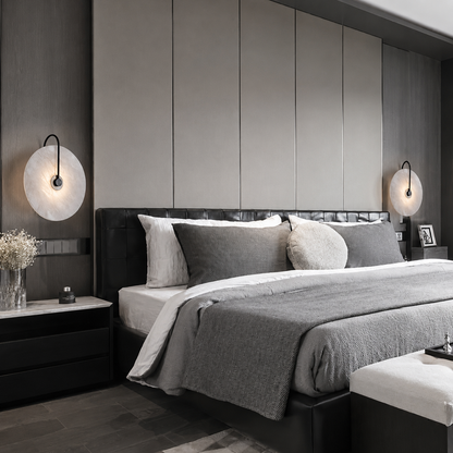 A modern bedroom featuring  two black wall sconces on either side of the bed