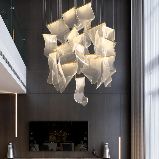 A modern multi-light pendant chandelier with translucent, wave-like white shades and warm gold-toned edges