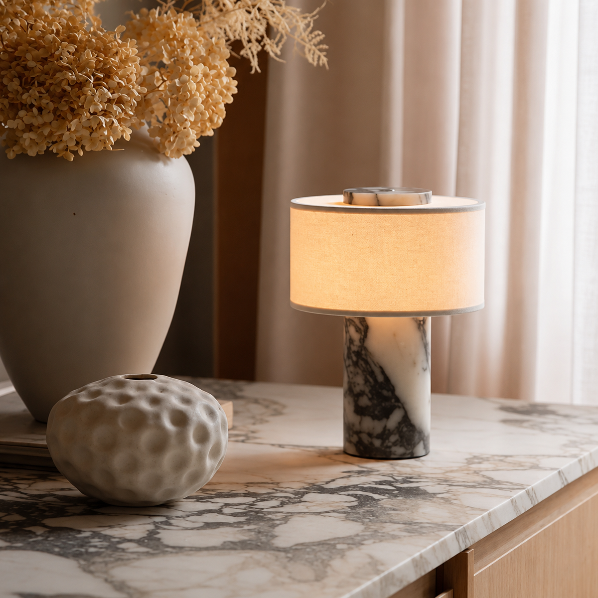A table lamp with fabric drum shade and a white marble base with black veining