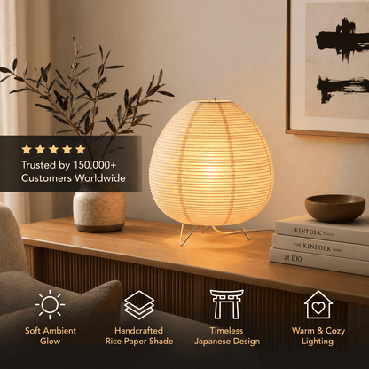 A oval table lamp made of layered rice paper stands on a wooden console table