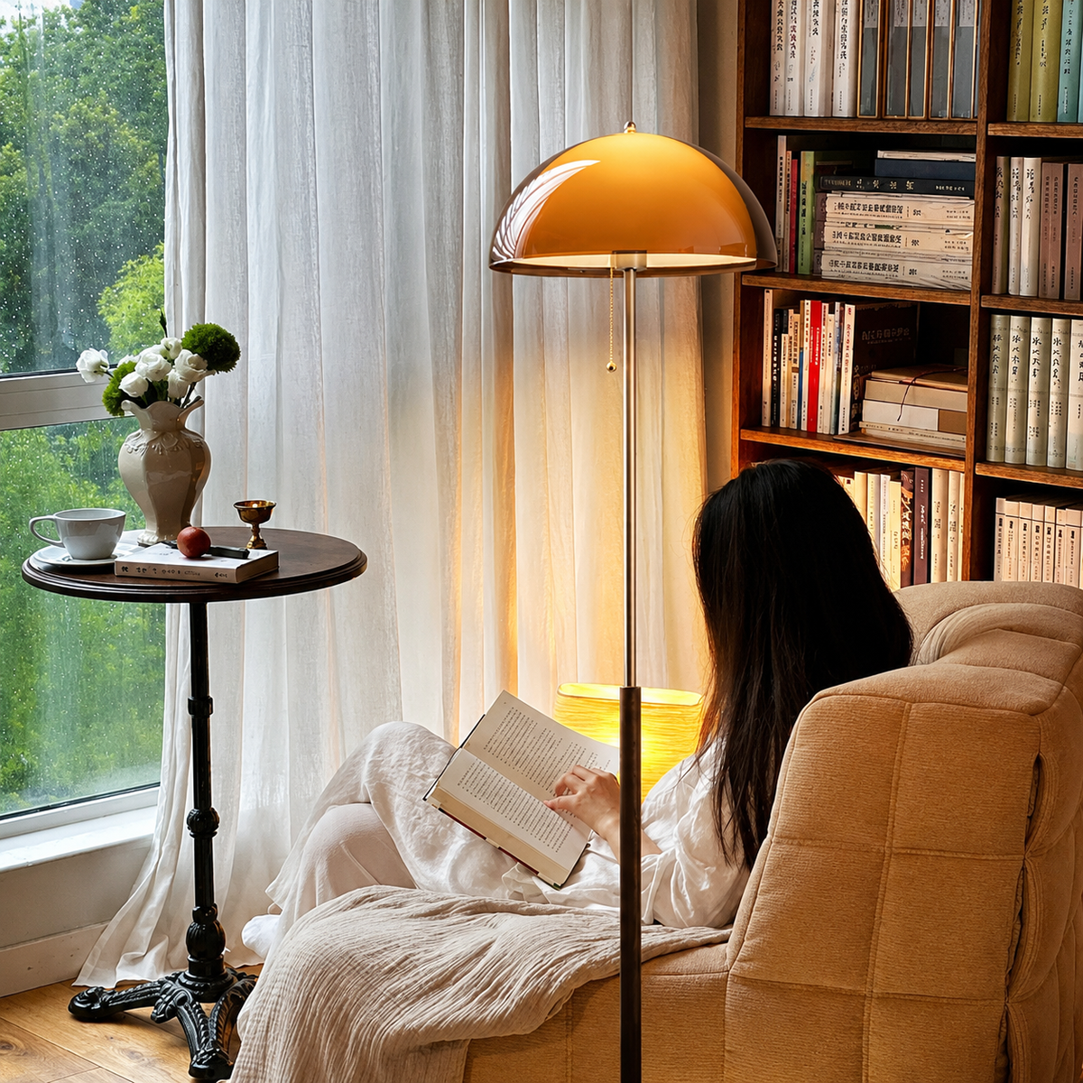 A modern floor lamp with a glossy dome shade in warm amber-orange and a polished silver metal pole