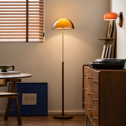 A modern floor lamp with a warm amber dome shade