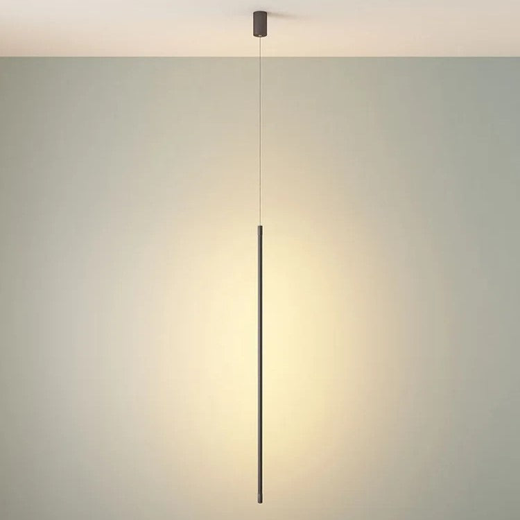 A minimalist linear pendant light with a slim dark metal rod suspended from a ceiling
