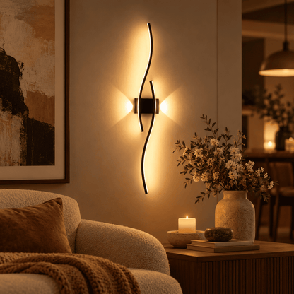 A modern wall-mounted light fixture with two curved black metal arms glowing warm light