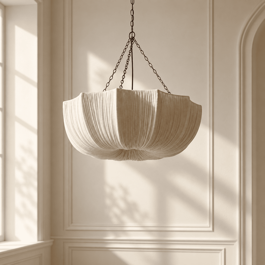 A cream-colored pleated fabric pendant light hangs from a dark metal chain 