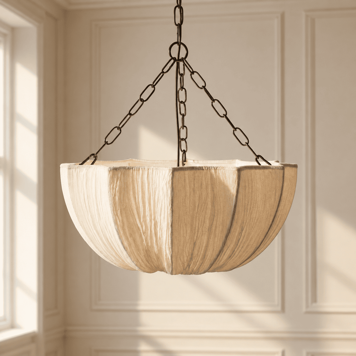 A hanging pendant light with a large, pleated drum shade in a beige tone