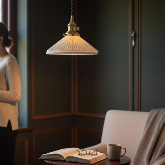 A warm, vintage-style pendant light with a ribbed glass shade and brass fixture hanging in a cozy room