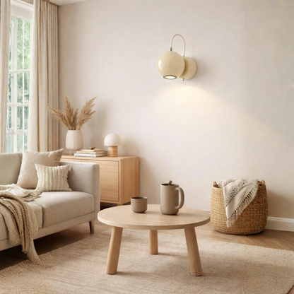A modern wall-mounted two-light sconce in a warm cream finish